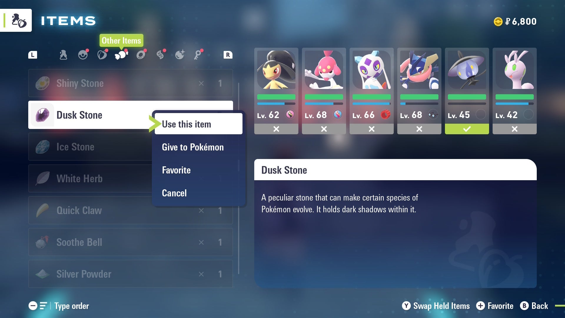 Игрок собирается дать Lampent Сумеречный камень из сумки в Pokémon Legends Z-A